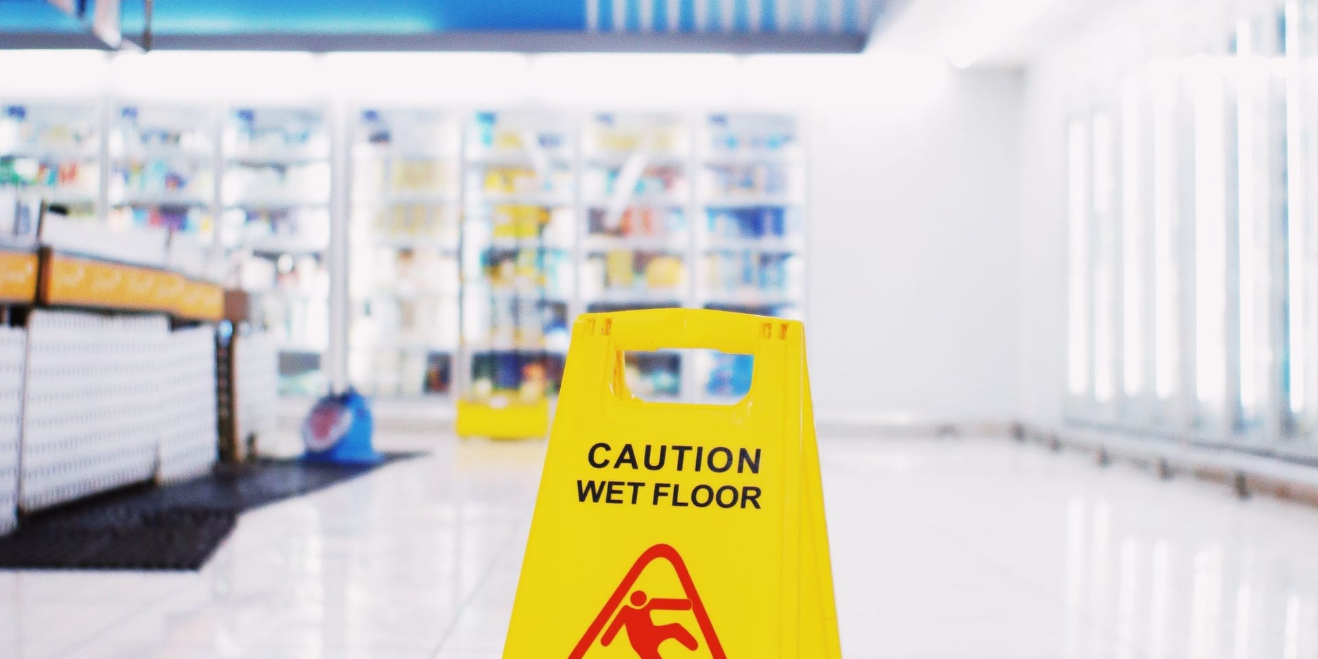 A caution wet floor sign standing on a freshly mopped commercial floor